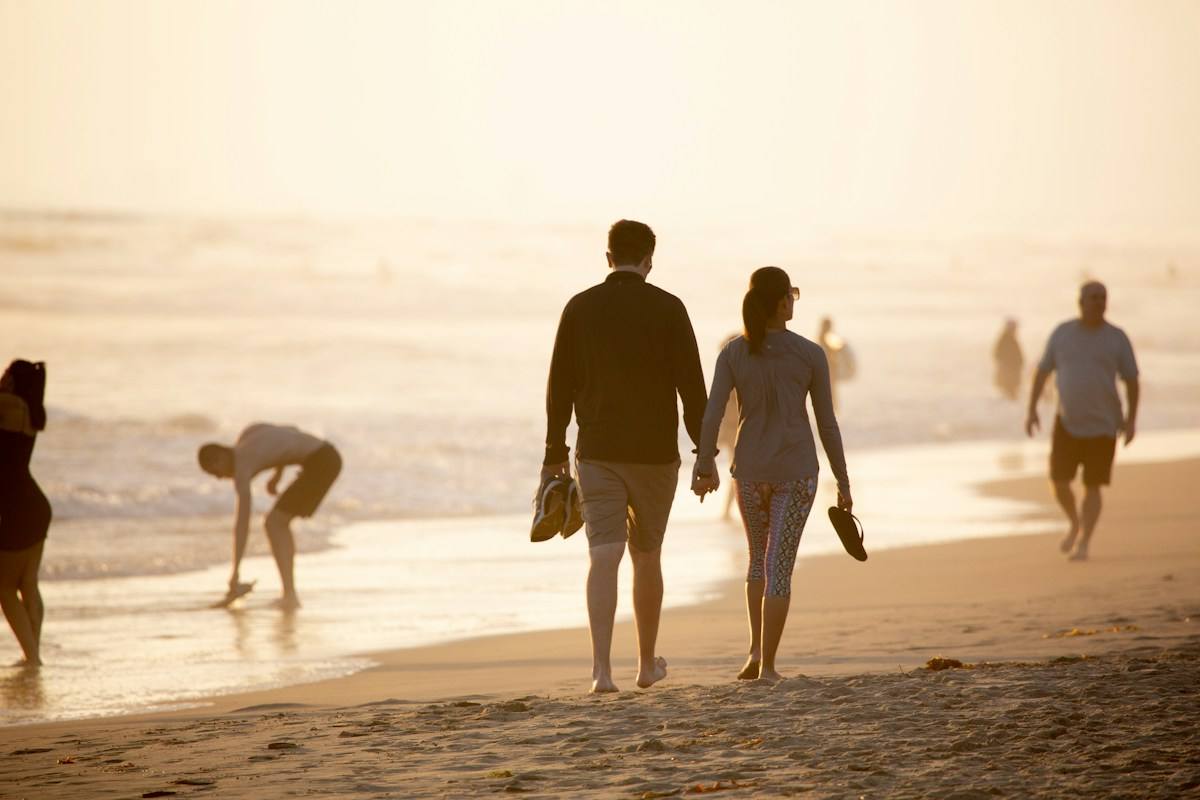 A couple walking together on a bright beach