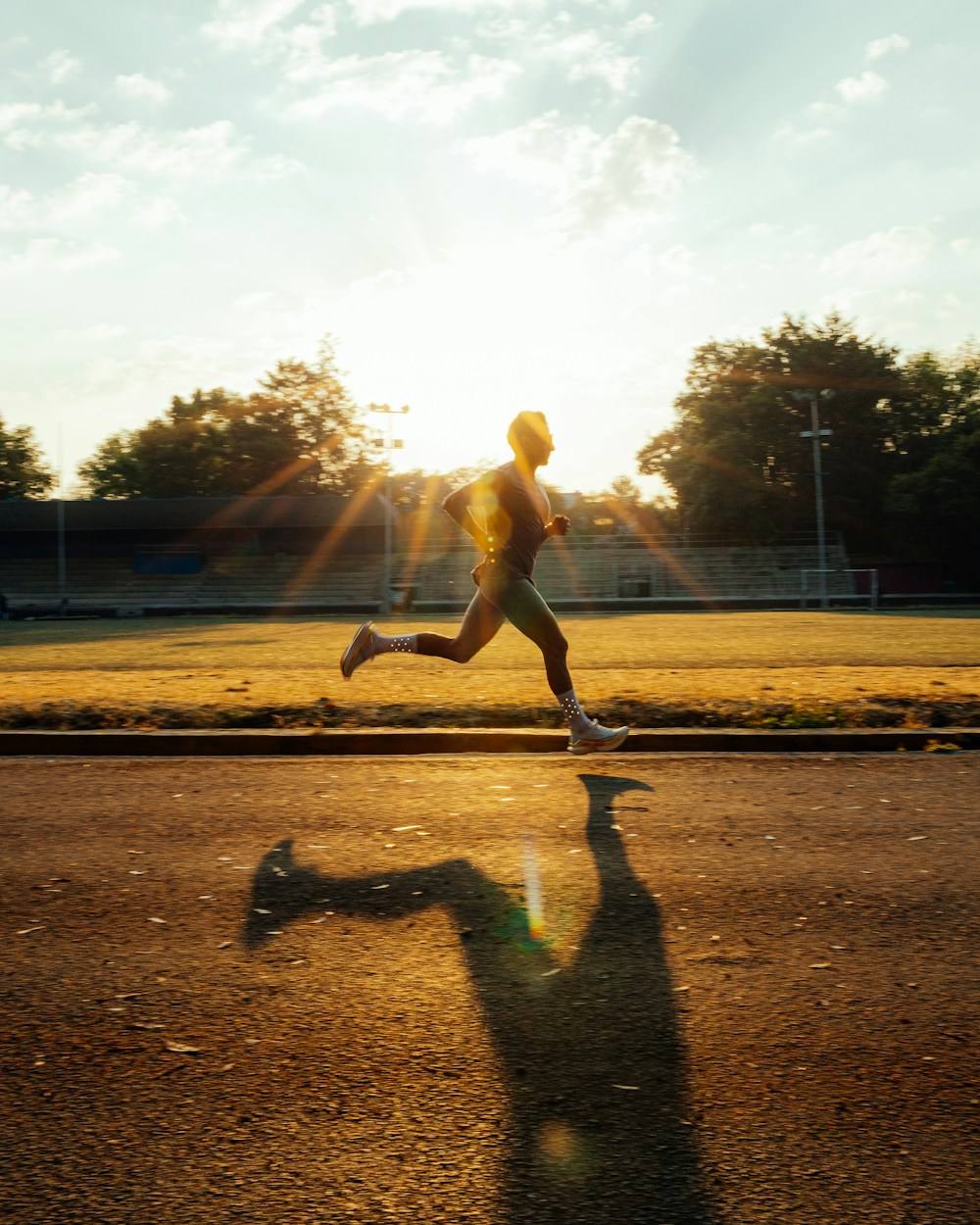 A runner on a track in golden morning light
