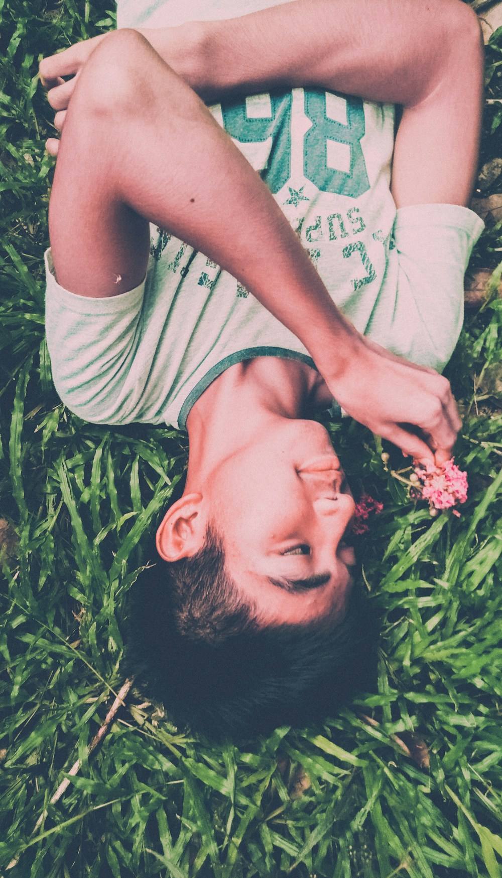 A smiling boy lying in the grass